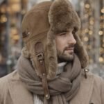 Genuine sheepskin trapper hat with natural fur lining and ear flaps, classic winter aviator style