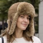 Genuine sheepskin trapper hat with natural fur lining and ear flaps, classic winter aviator style